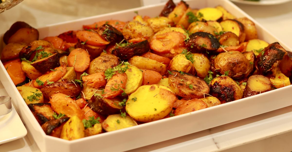 Batatas e legumes assados em uma assadeira