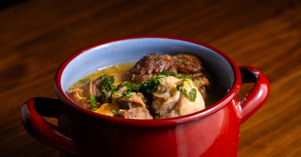 Panela vermelha com carne cozida lentamente e legumes