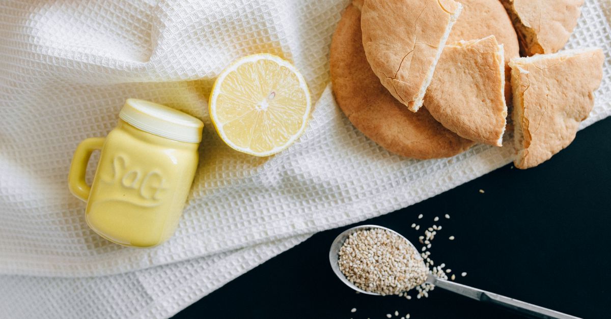 Limão, saleiro e pão sírio sobre um pano de cozinha
