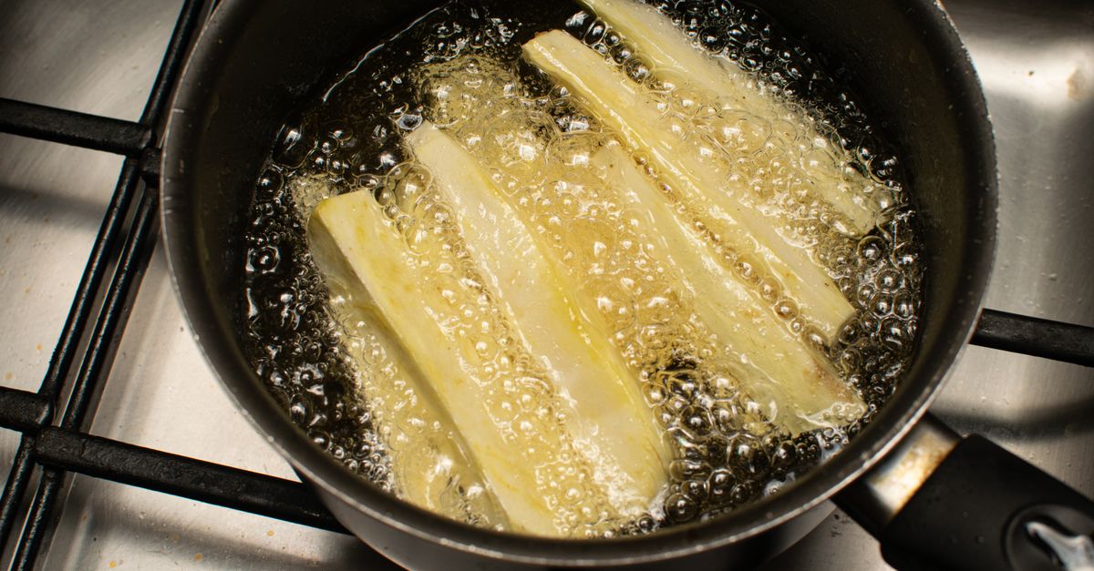 Alimentos fritando em óleo quente dentro de uma panela