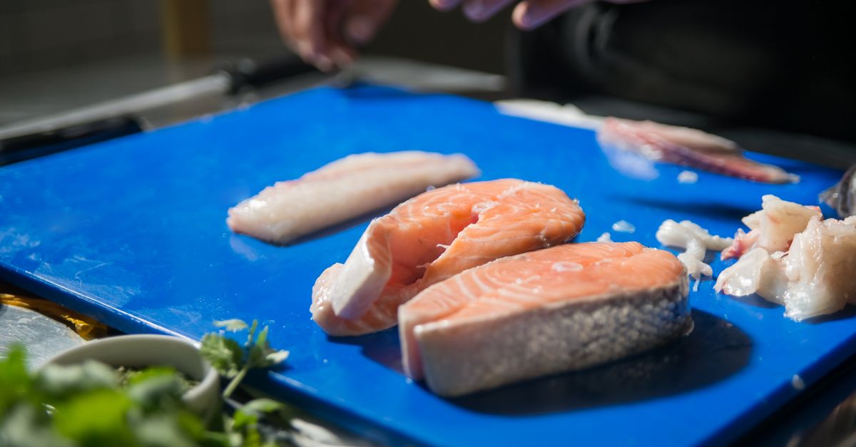 Filés de peixe crus sobre uma tábua azul