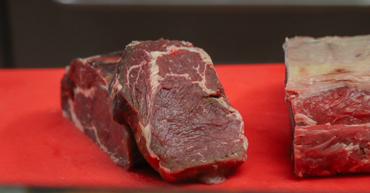 Cortes de carne bovina crua sobre uma tábua vermelha