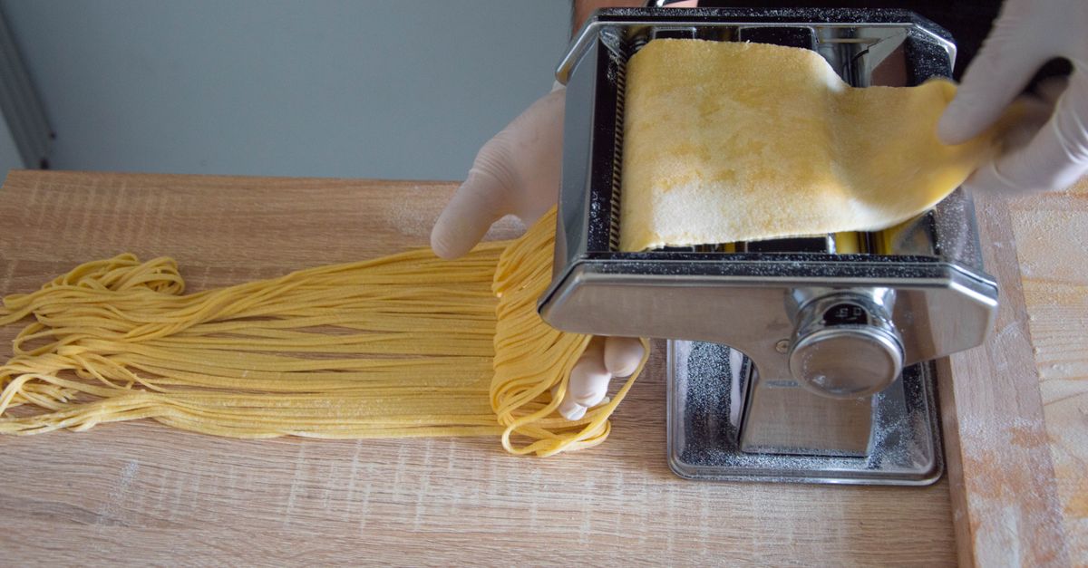 Máquina de abrir massa produzindo macarrão fresco